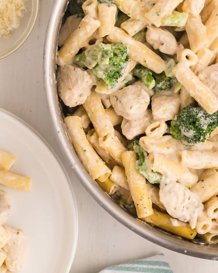 A top view of a pan and a serving plate with chicken broccoli ziti.