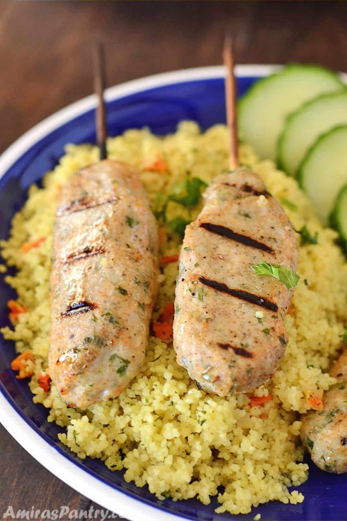 Chicken Kofta skewers on a blue plate with yellow rice.
