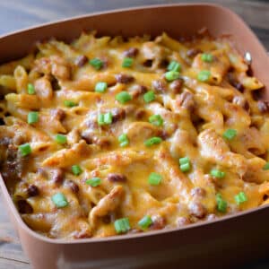 Chicken enchilada pasta casserole topped with melted cheese.