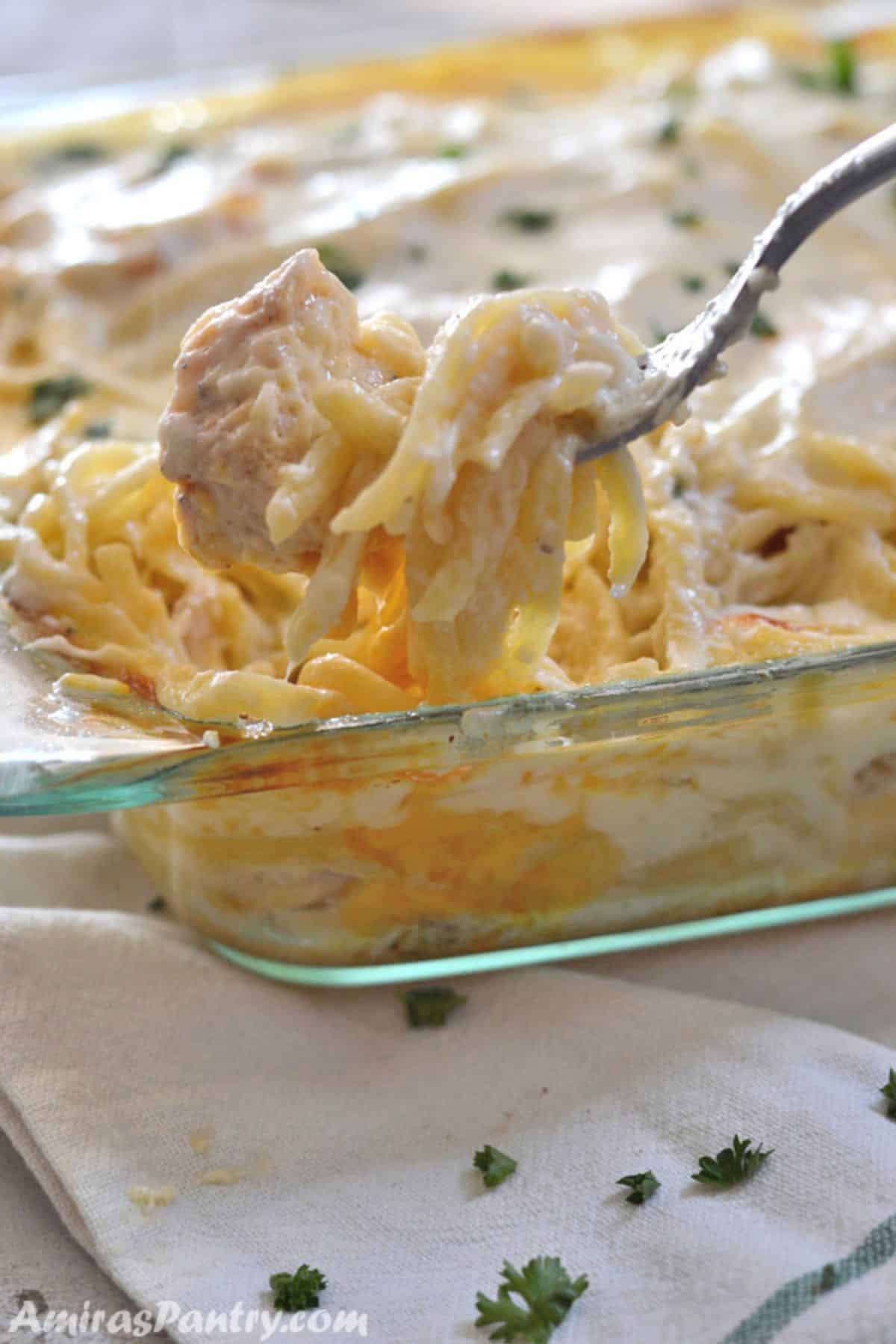 Chicken tetrazzini in a casserole with a fork.