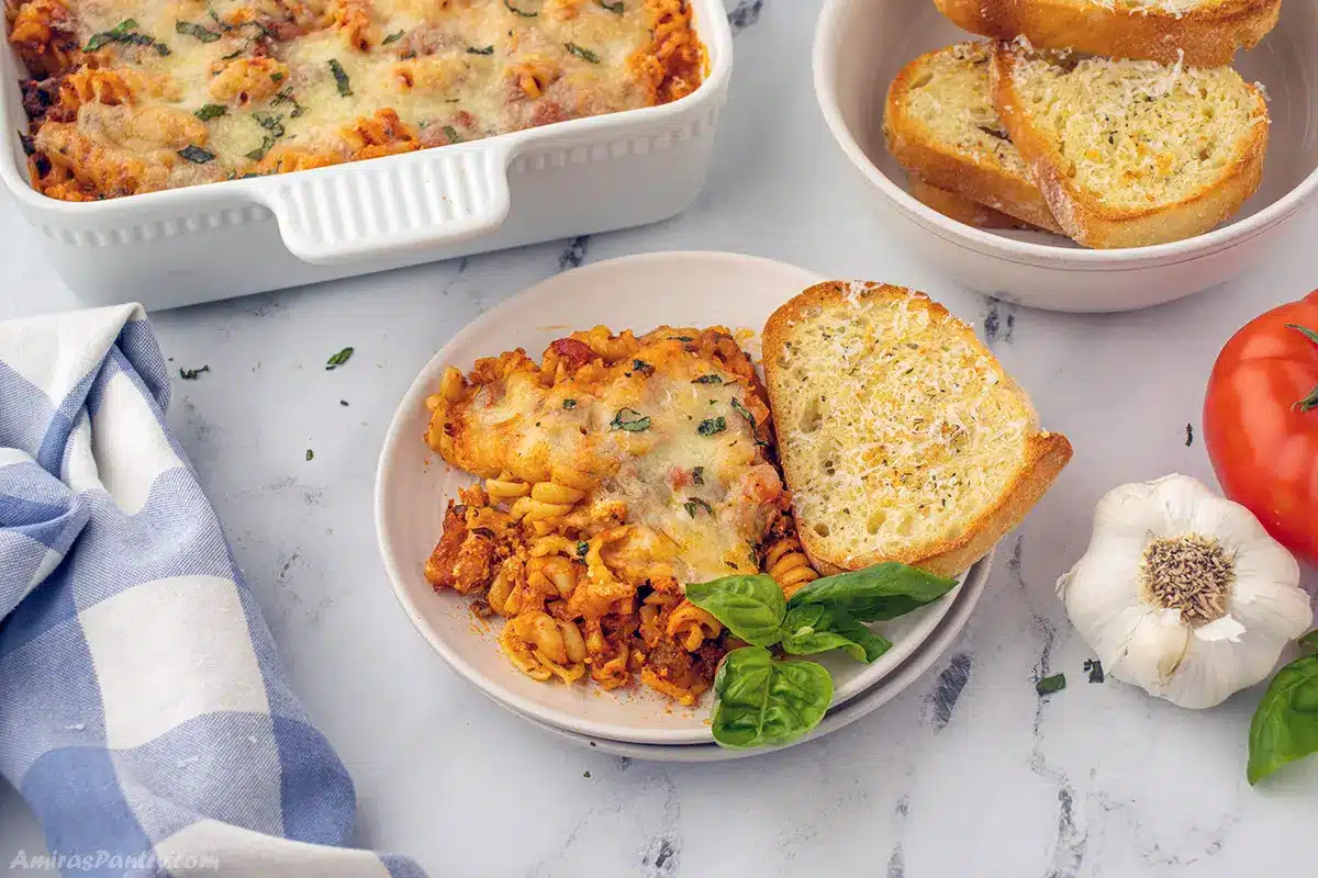 Easy lasagna casserole on a dish with garlic bread.