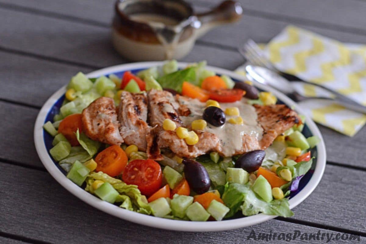 A plate with healthy grilled salad topped with olives.