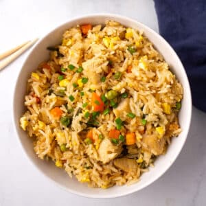 A big white bowl of instant pot chicken fried rice garnished with green onions.