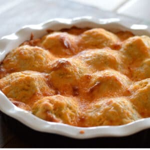 A baking dish with baked mashed potato casserole showing the top golden melted cheese.