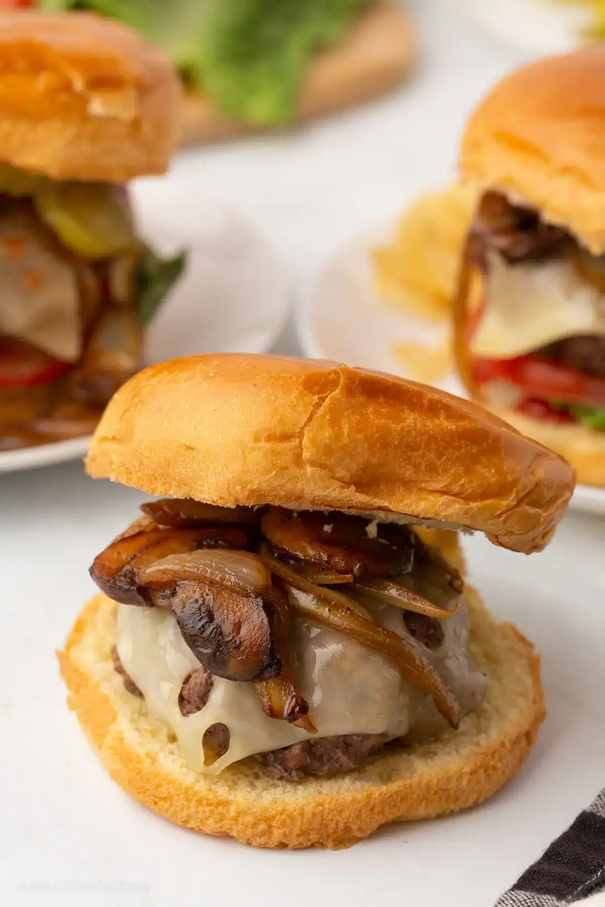 A close up image of a mushroom Swiss burger sandwich.