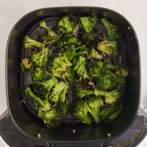 Broccoli in the air fryer topped with parmesan cheese.