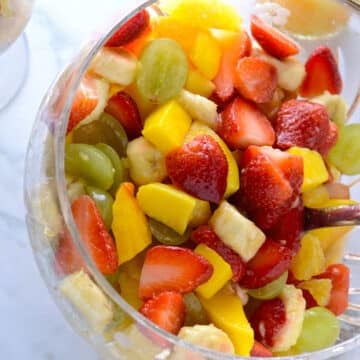 A big bowl of fruit salad with a spoon.