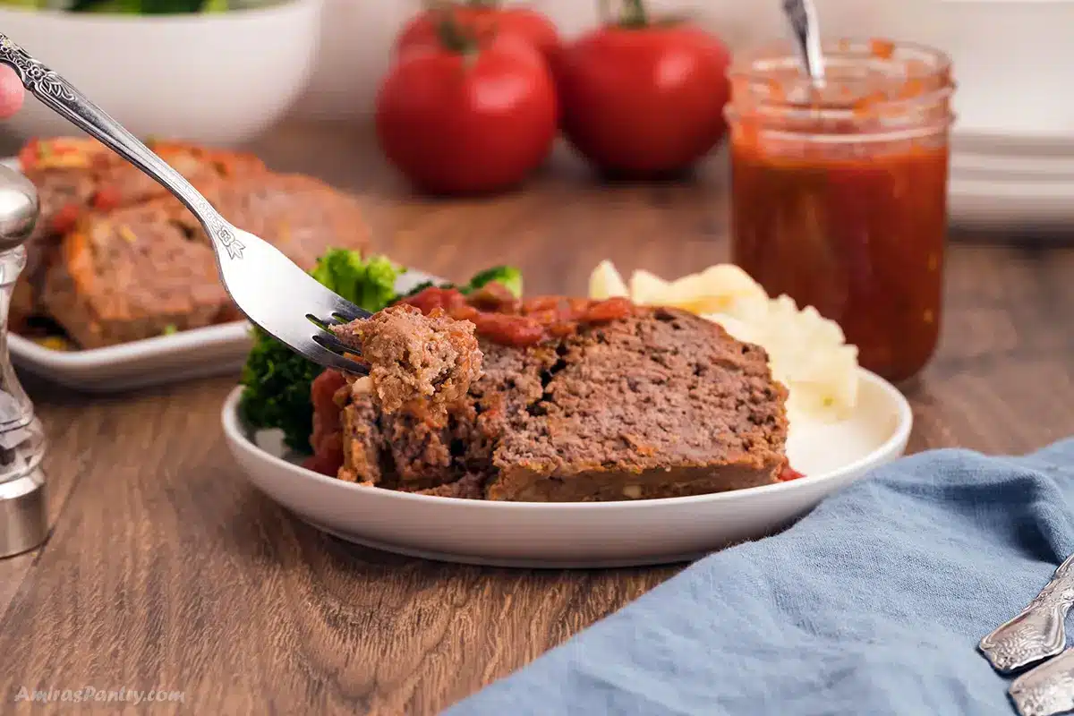 A fork with a piece of salsa meatloaf.