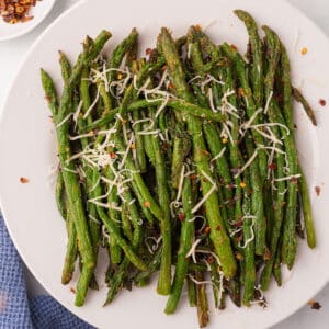 An overhead view of a white plate with air fryer asparagus.