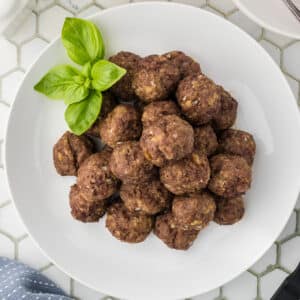 An overhead view of a white plate piled up with bison meatballs.