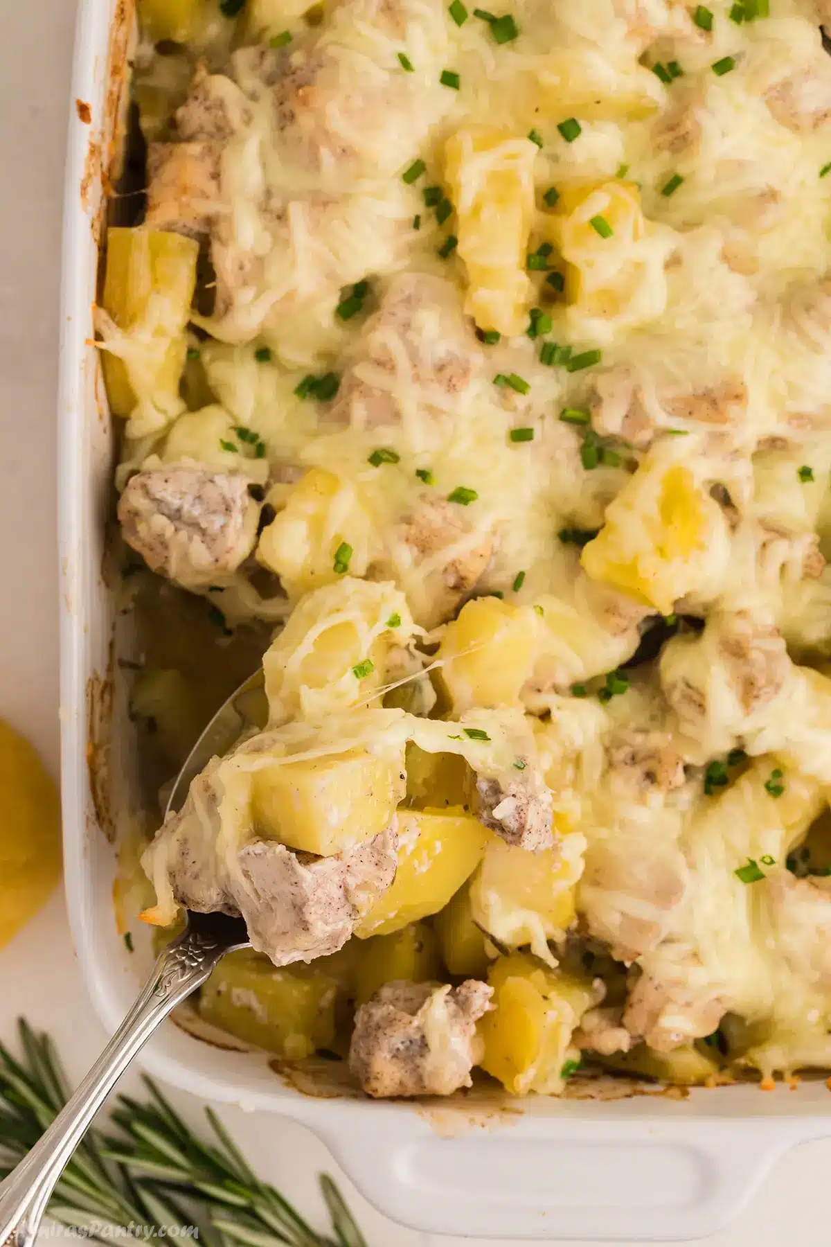 An overhead view of a chicken and potato casserole with a spoon in it.