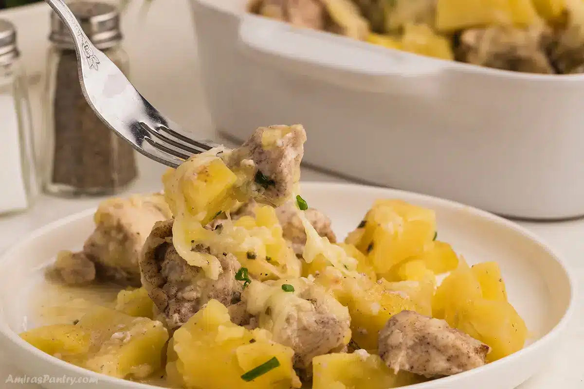 A fork with some chicken potato casserole.