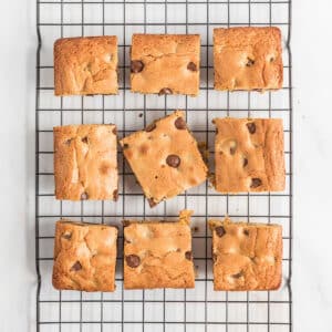 A top view of chocolate chip blondies squares on a wire rack.