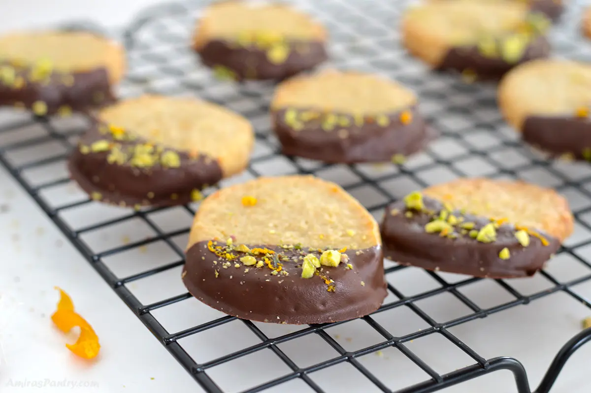 Chocolate orange cookies on a wire rack garnished with pistachios.