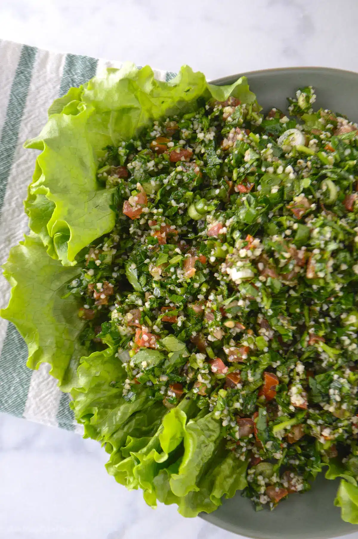 Tabbouleh salad on a bed of lettuce.