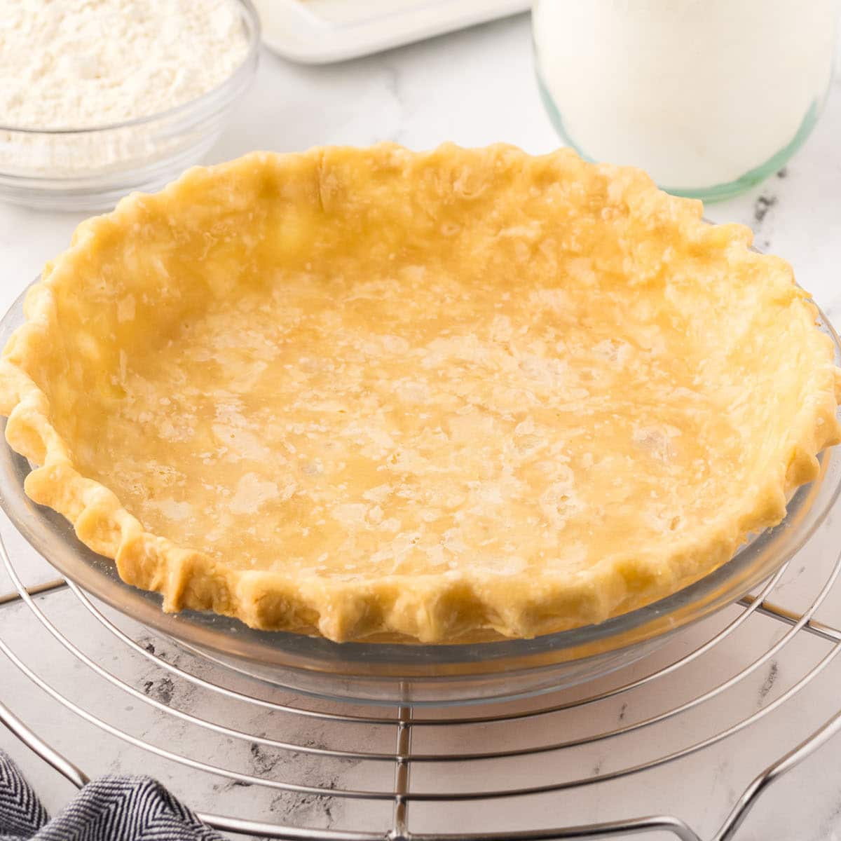 Baked pie crust on a glass pie dish.