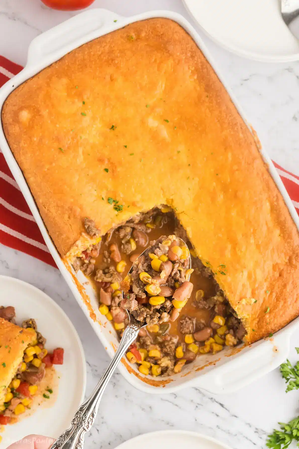 An overhead image of the cornbread casserole with a serving spoon.
