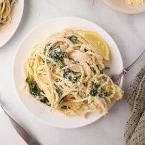 A round white dish with a serving of ricotta cheese pasta.