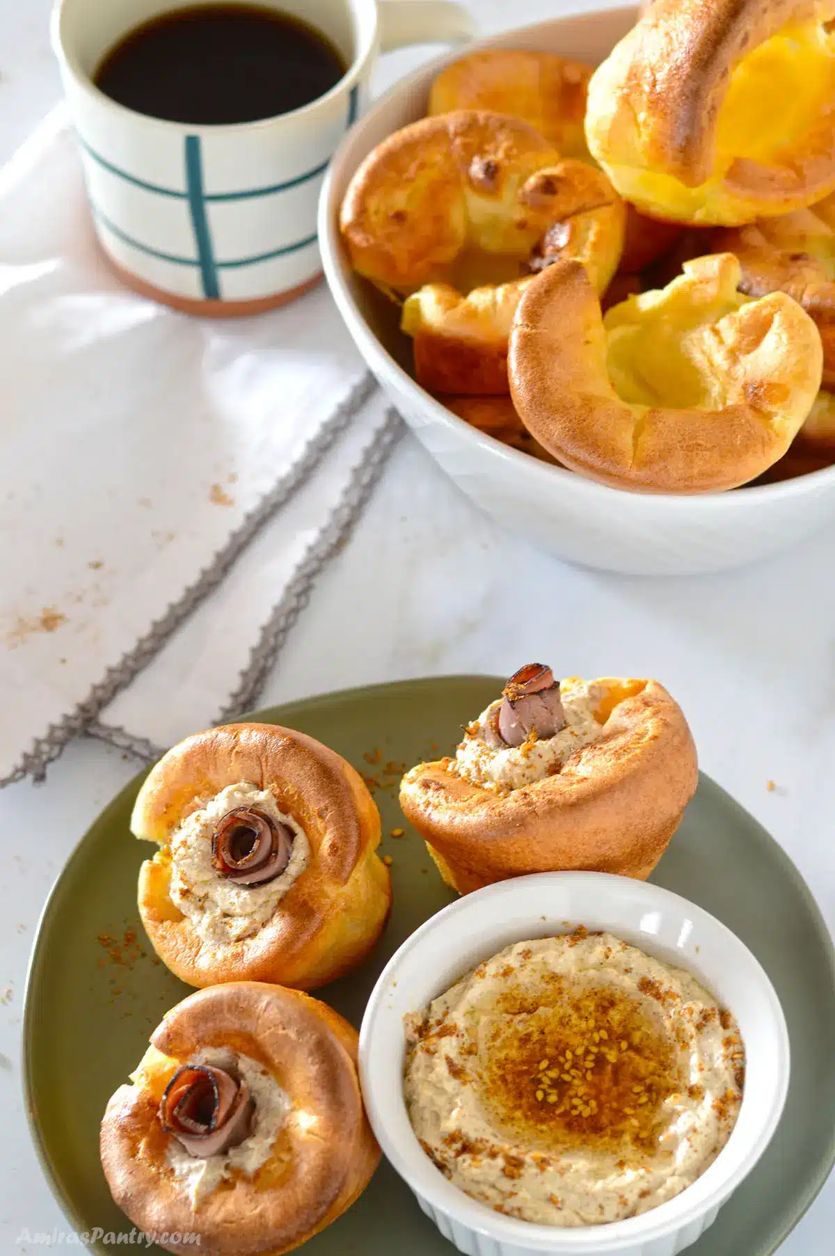 A top view of a breakfast table with yorkshire pudding filled with roast beef and cheese.