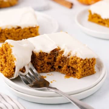 A square of pumpkin cake with s bite taken from it.