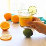 A hand holding a glass or virgin margarita.