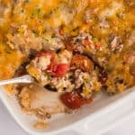 Bell pepper hot dish in white casserole dish with a spoon.