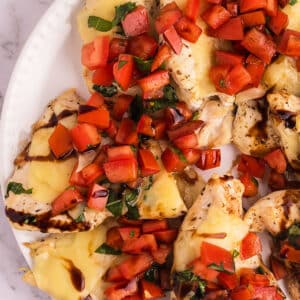 A zoomed in image of chicken recipe with bruschetta.