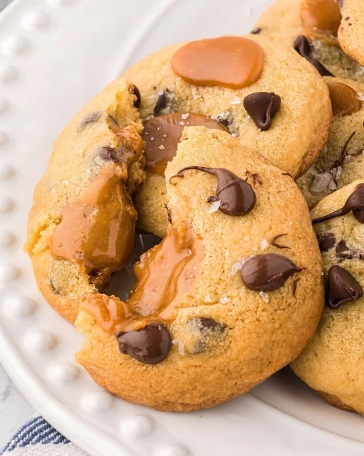 Caramel chocolate chip cookie cut in half and placed on a plate.