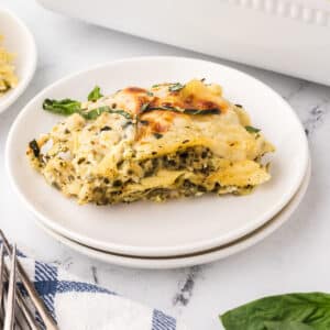 A serving of chicken pesto lasagna on a white plate.