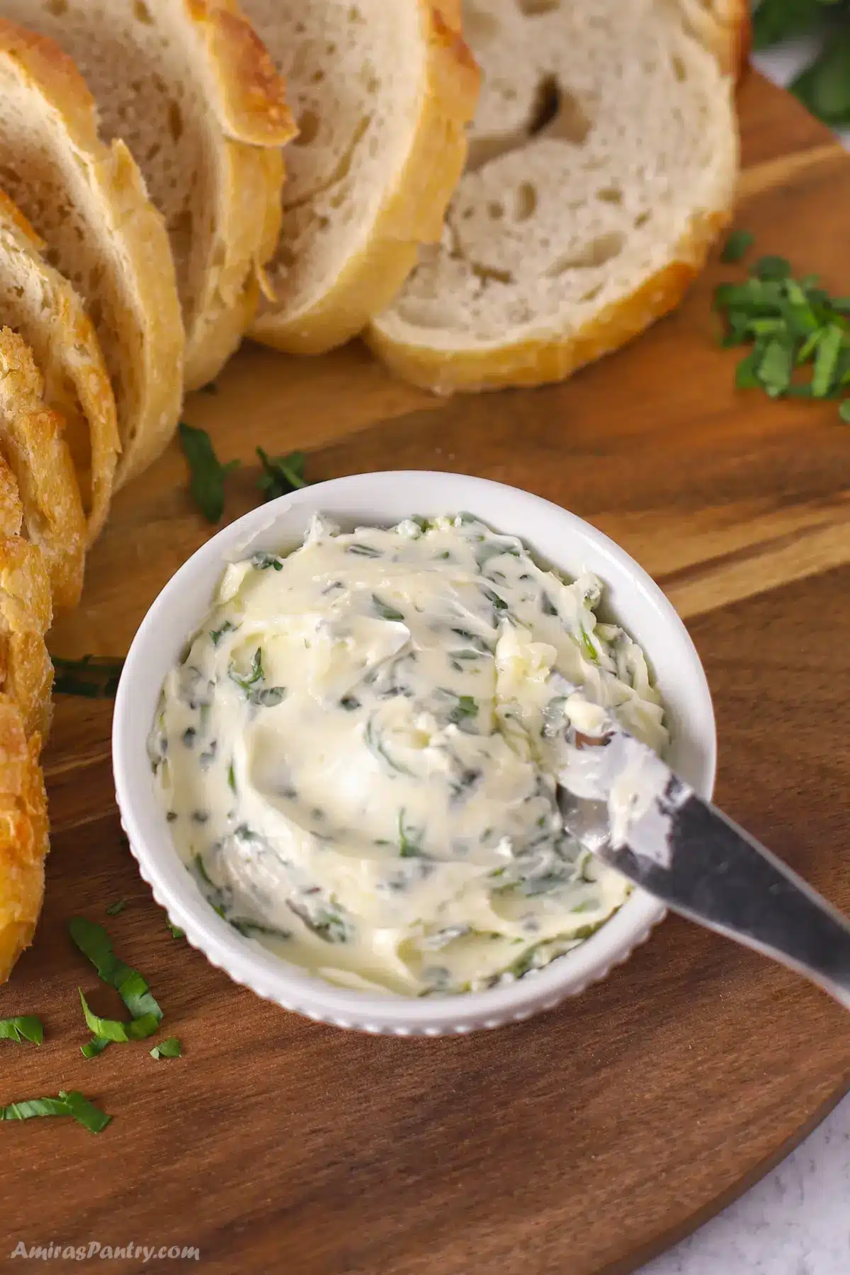 A bowl of garlic butter with bread on the side.