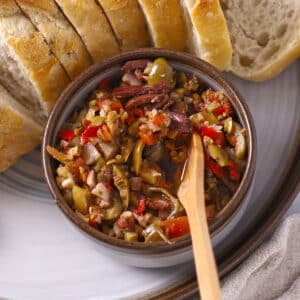 Olive salad in a small bowl with toast on the side.