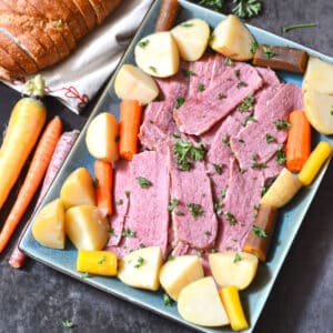 An overhead image of sliced corned beef with vegetables.