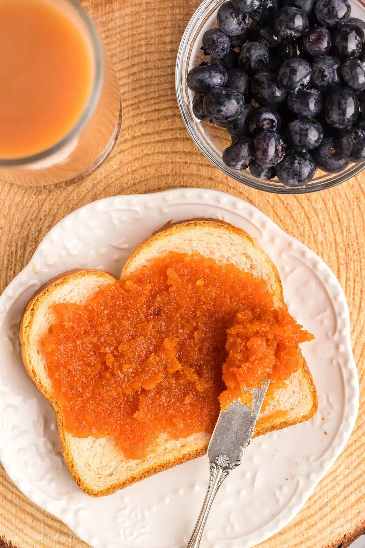 Breakfast toast with some carrot jam on a white plate.