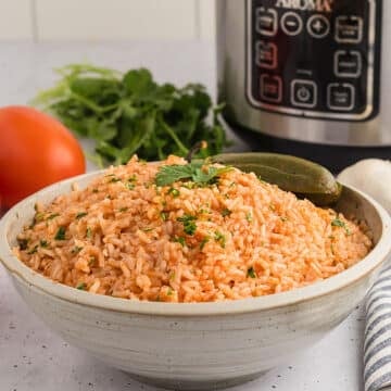 Mexican rice in a white bowl garnished with cilantro.