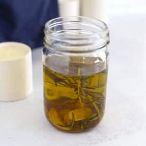 Garlic oil with herbs in a jar.
