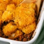 A close up image of a spoon with a serving of sloppy joe tater tot casserole.