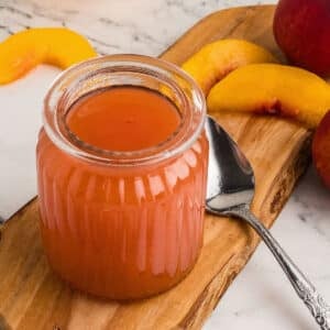 An overhead image of a jar with peach syrup.
