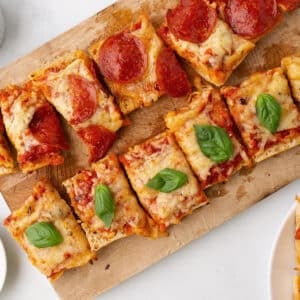 An overhead images of garlic bread pizza sliced and garnished with fresh basil.