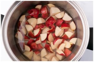 Potatoes covered with cold water in a pot.