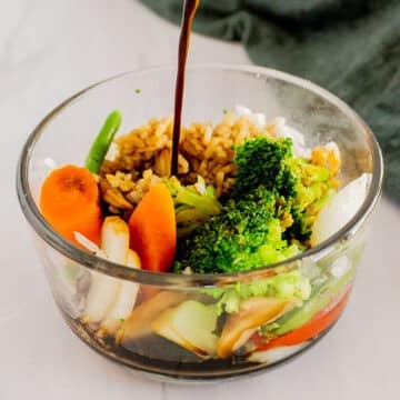 A close up image of a bowl of vegetables with stir fry sauce.