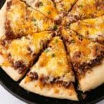 An overhead image of a pizza with a slice pulled out.