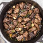 An overhead image of a black skillet with steak bites.