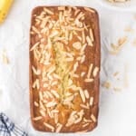 A loaf of banana bread on a white marble surface.