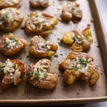 A close up on a baking sheet with potatoes.