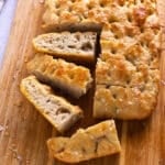 Focaccia slices on a wooden cutting board.