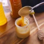Small metal spoon scooping some whipped honey off a jar.
