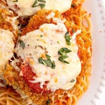 An overhead image for chicken parmesan garnished with basil.