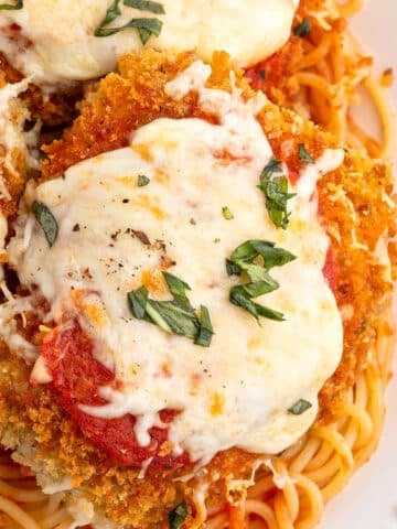 An overhead image for chicken parmesan garnished with basil.