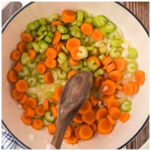 Cooking mirepoix ingredients in a deep pot.