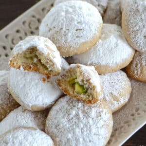 A close up image on a stack of kahk cookies on a white plate.